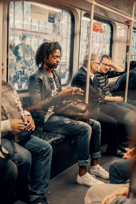 image of a man travelling in a metro train with his earphones