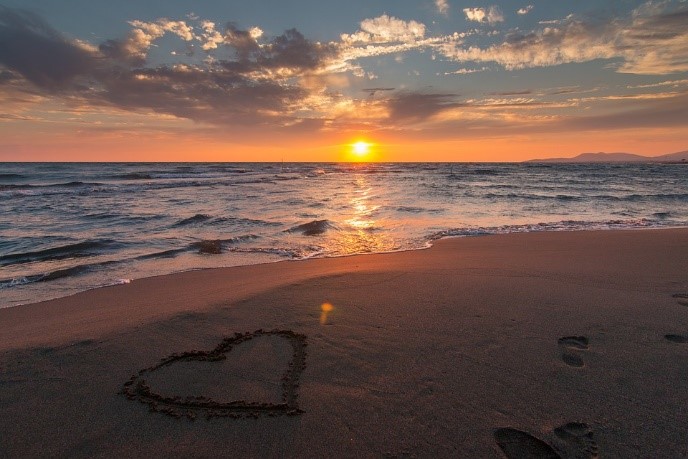 image of a sunset and a heart symbol on the beach